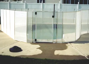 White mesh pool fence section with a self-closing gate